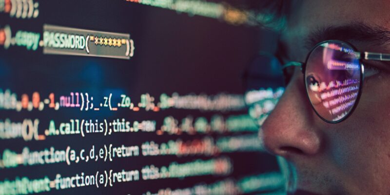 Hacker using computer, smartphone and coding to steal password and private data. Screen with code